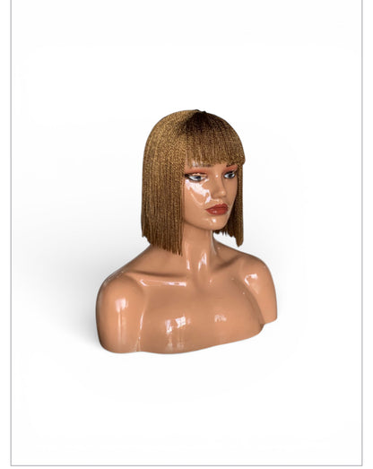Bangs Twist wig on mannequin head: lightweight, no-lace, pre-tinted bob with blunt bangs.